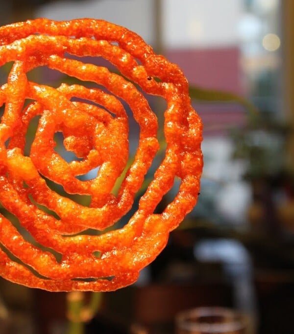 A jalebi being held towards the camera