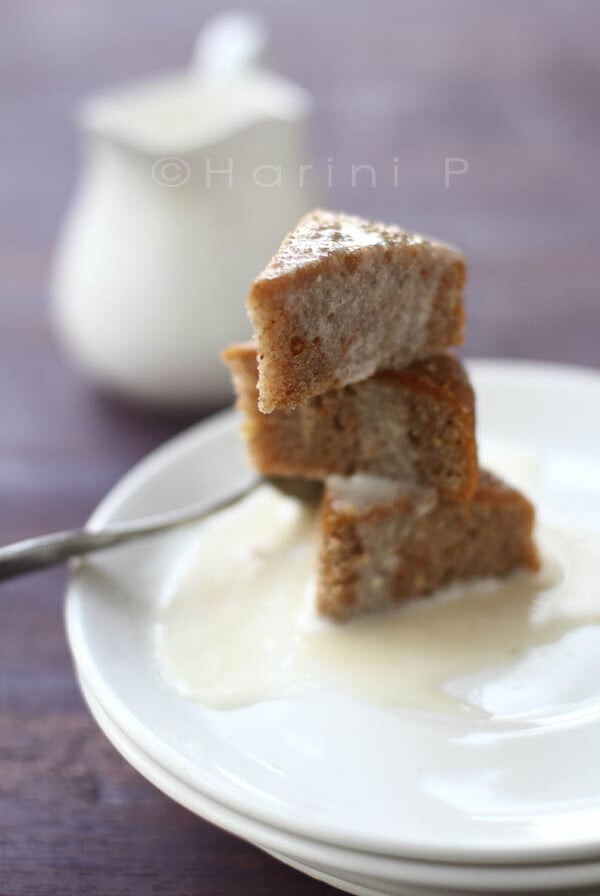 Pieces of gluten free carrot cake stacked on a white plate