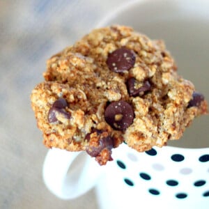 Oatmeal chocolate chip cookie resting on a mug