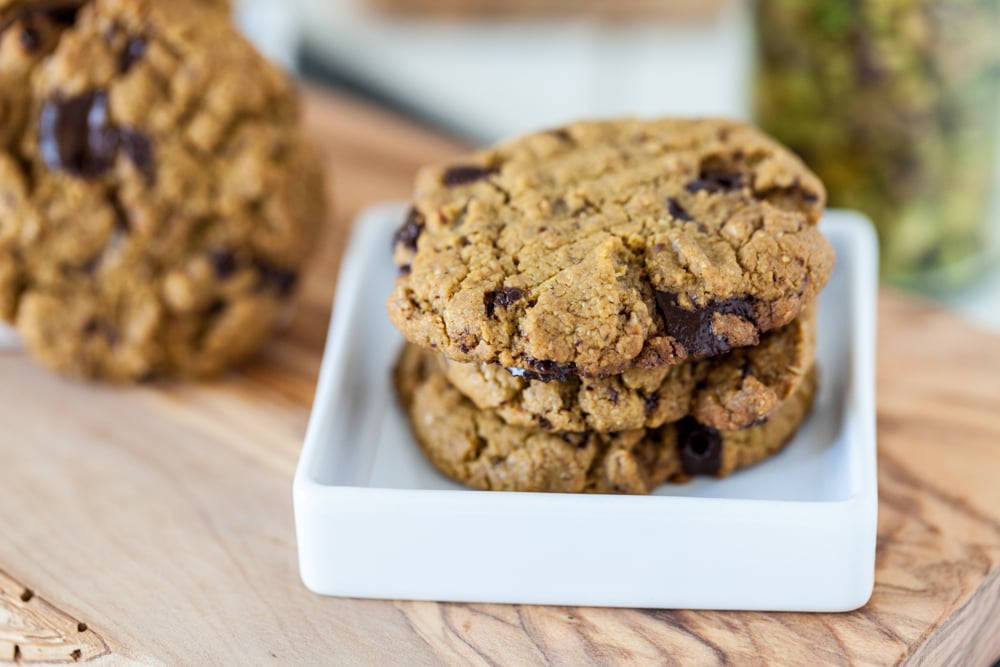 gluten free pistachio butter cookies on small white plate on wooden board