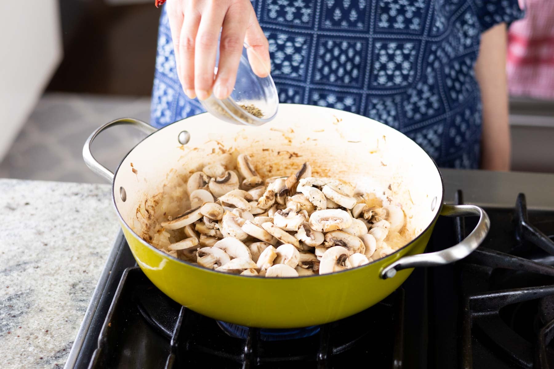 adding mushrooms and herbs to the pan