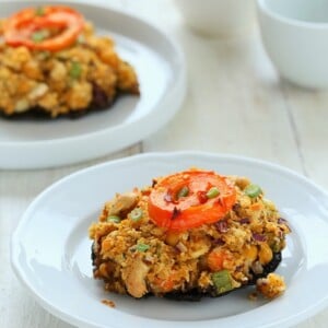 side view of vegan stuffed Portobello Mushrooms on a white plate