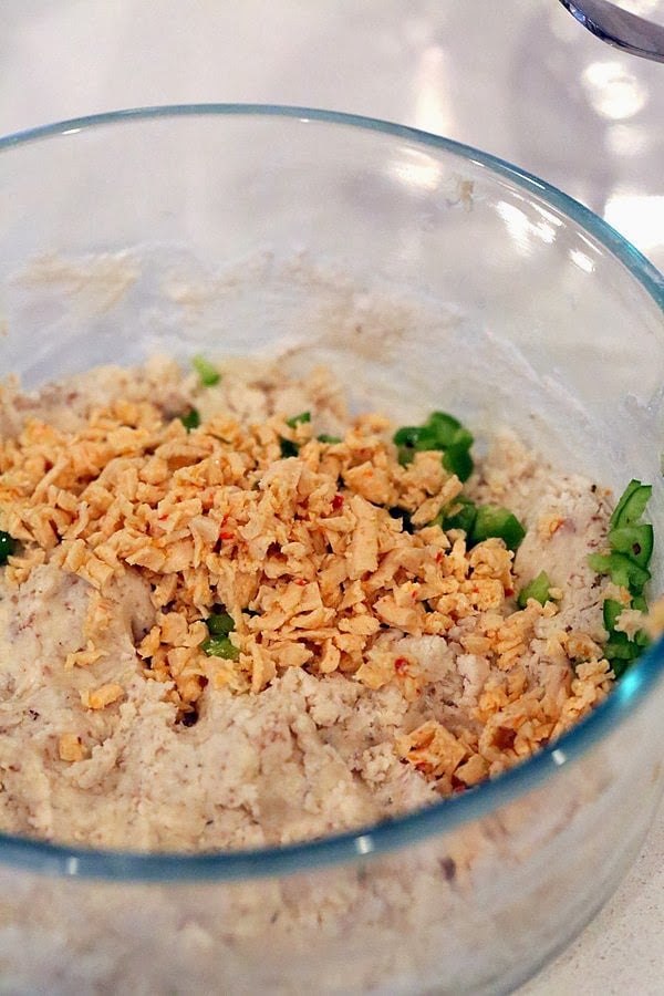gluten free biscuits recipe vegan pepper jack shreds and chopped jalapenos being added to gluten-free biscuits dough