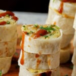 close-up of sliced samosa pinwheels on the cutting board drizzled with tamarind chutney