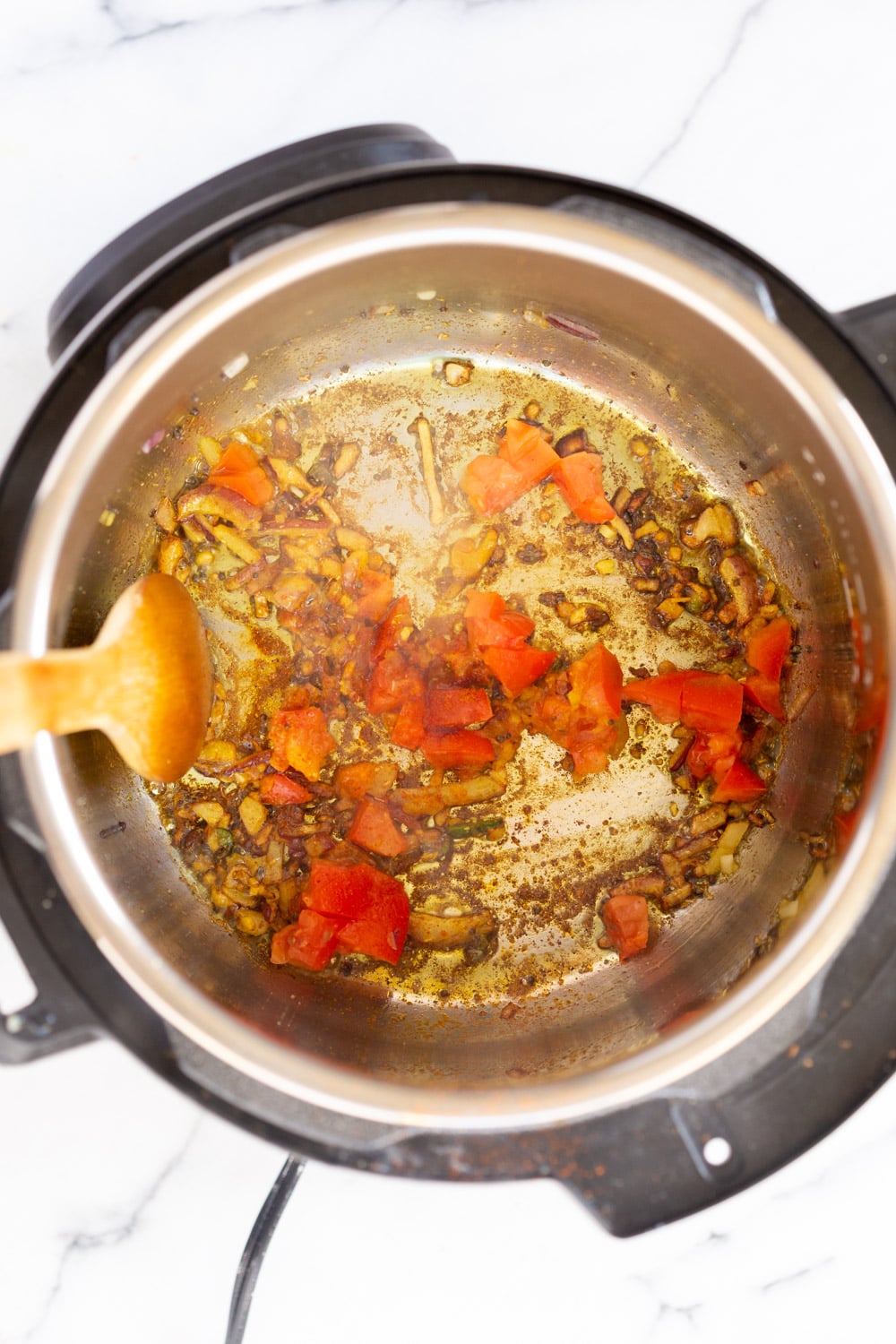 Instant Pot Kitchari onions, garlic and spices being fried in an Instant Pot to make Kitchari