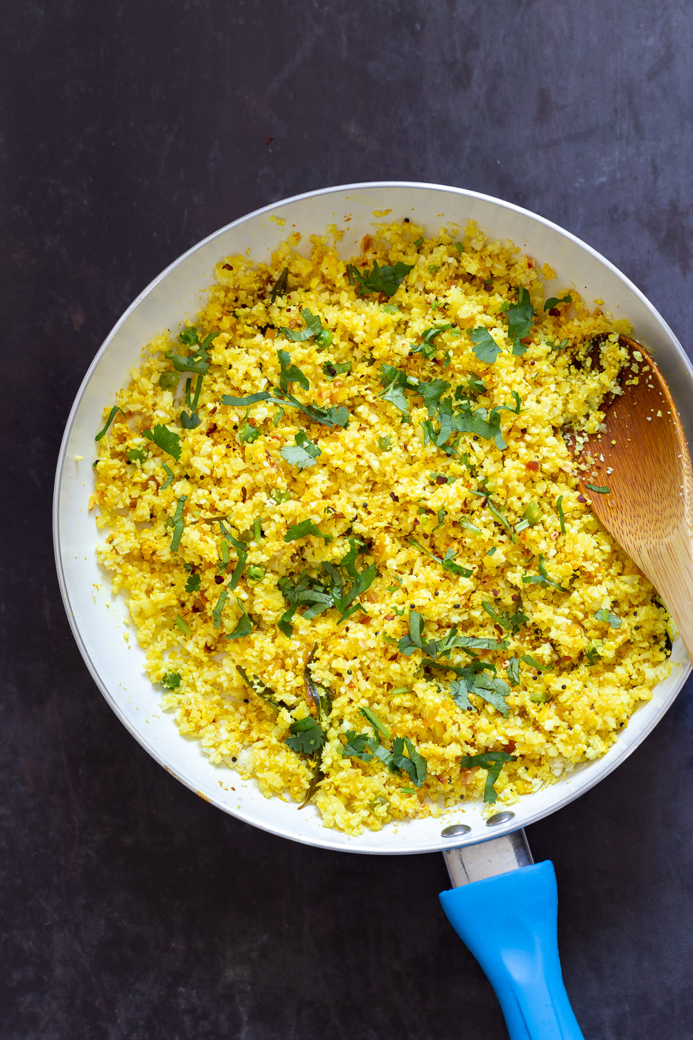 Lemony Turmeric Cauliflower Rice. Easy Side with any meal. 1 Pot Lemon Cauliflower Rice with mustard seeds and garlic in a White Skillet