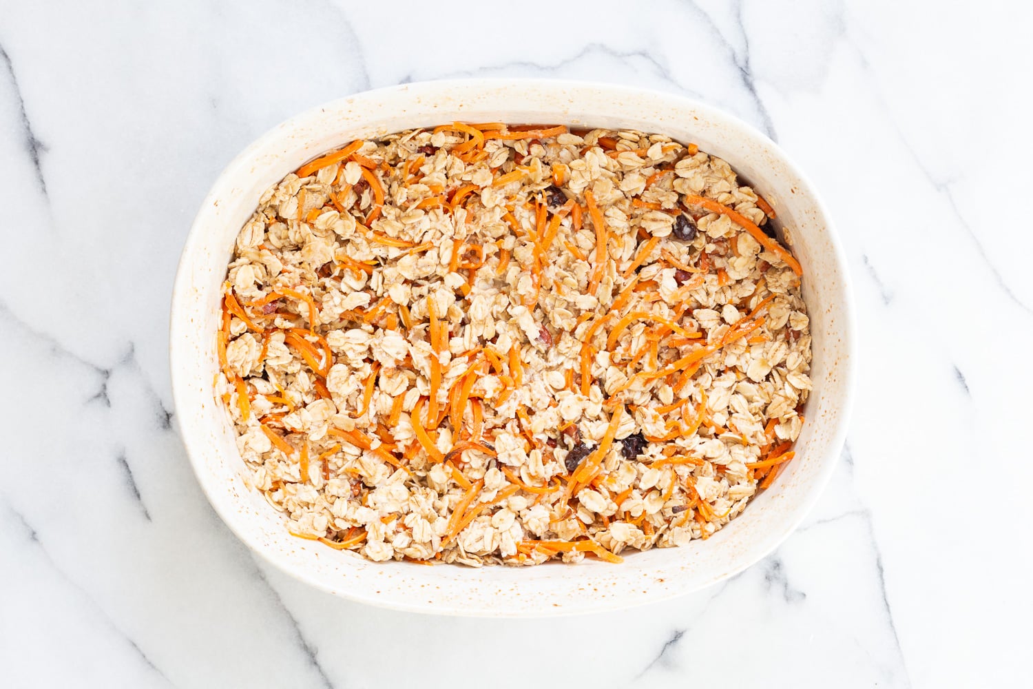 Our Vegan Carrot Cake Baked Oatmeal ready tobake in a white baking dish