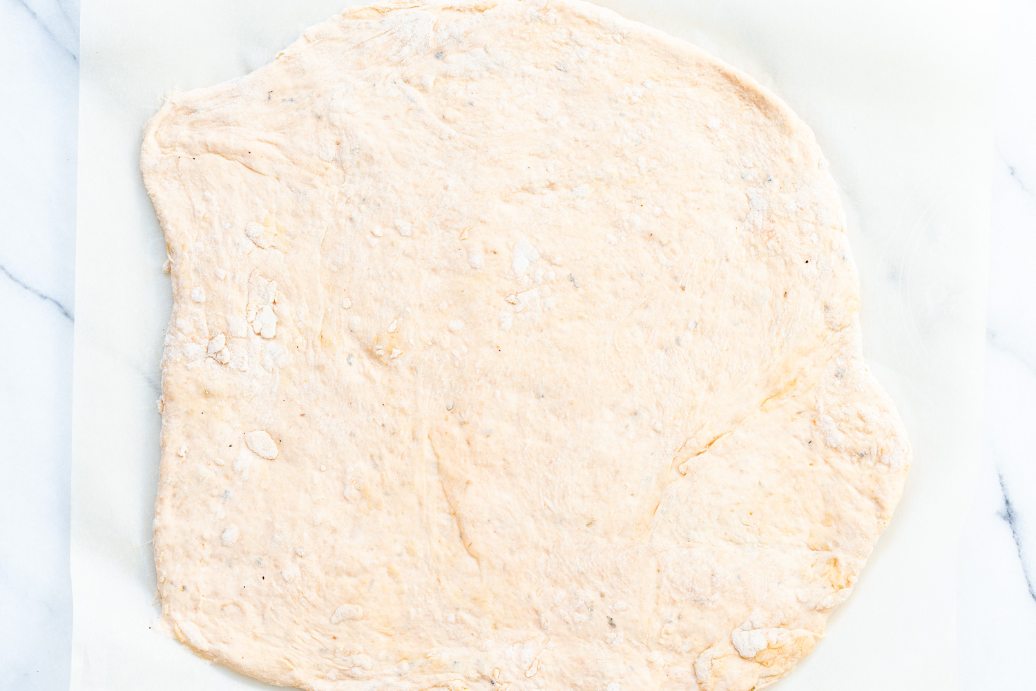 Vegan Pizza Rolls dough rolled out on parchment