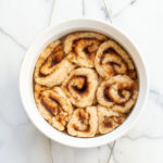 Our Vegan Gluten free Cinnamon rolls in a stoneware dish on marble