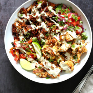 Chili Lime Roasted Veggies & Jackfruit drizzled with jalapeno cream sauce in a White Bowl