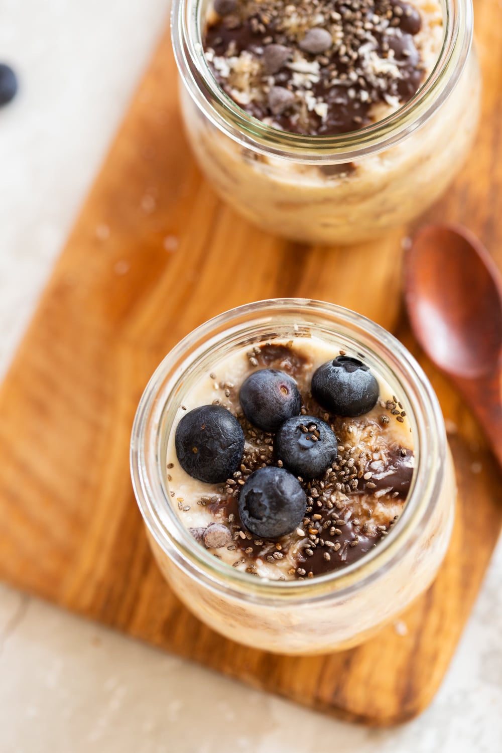 Our Vegan Samoa Cookie Overnight Oats in glass jars on a wood board