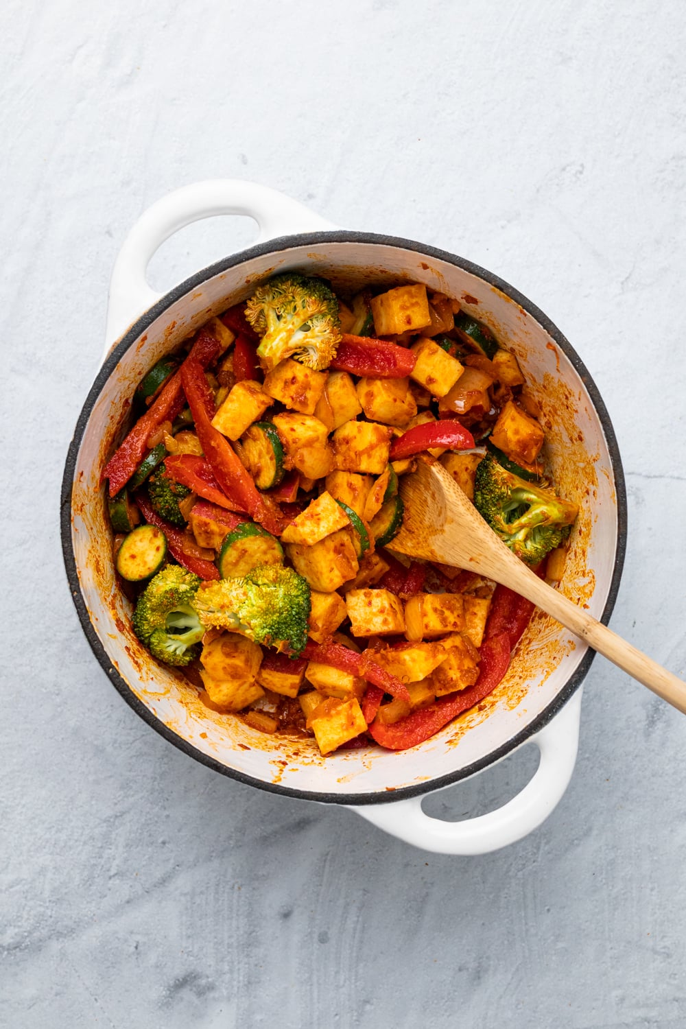 sweet potato curry vegetables and potatoes being sauteed with Thai red curry paste to make vegan curry