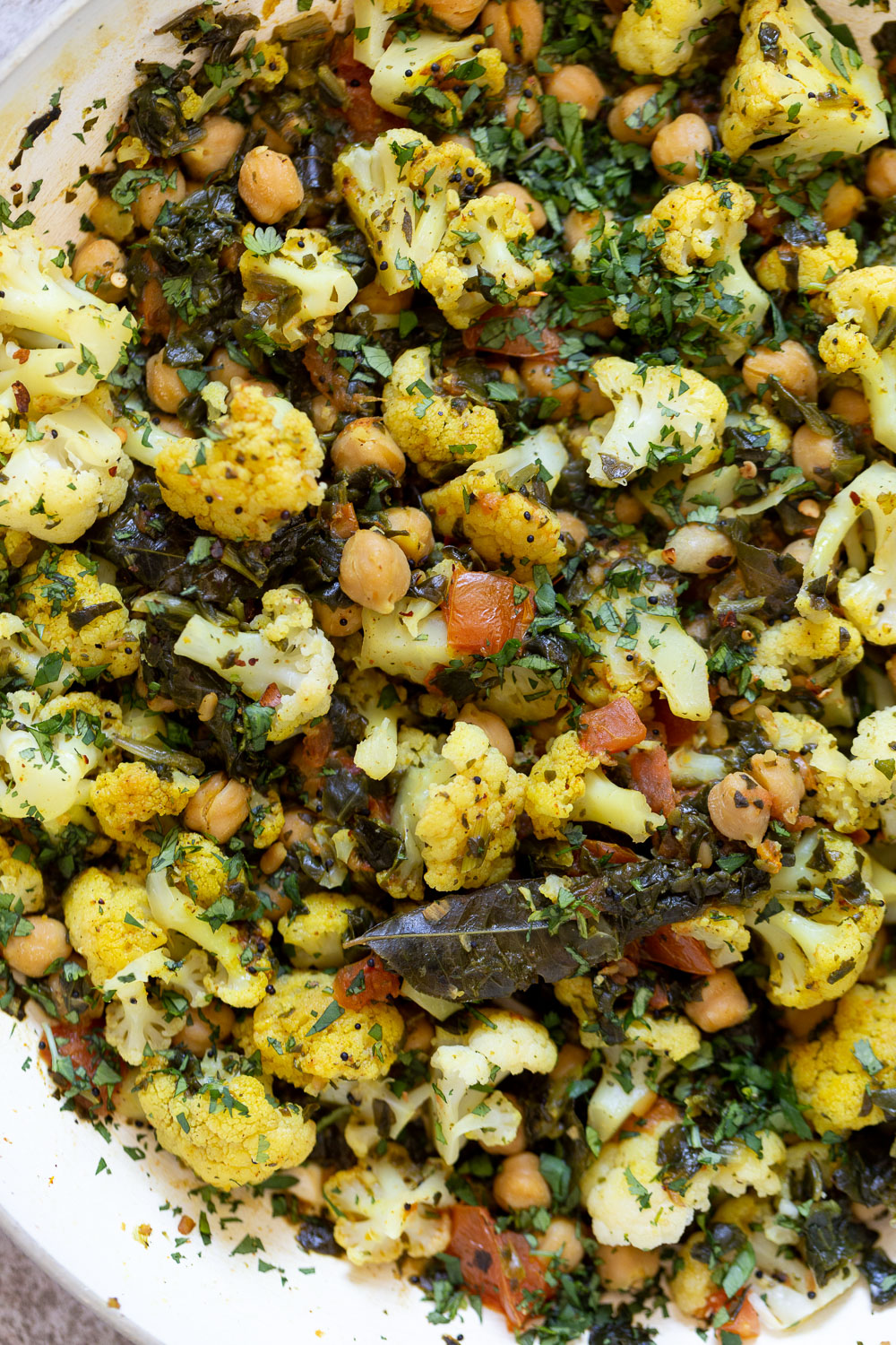 close-up overhead shot of a frying pan with cauliflower, chickpeas and spinach saute