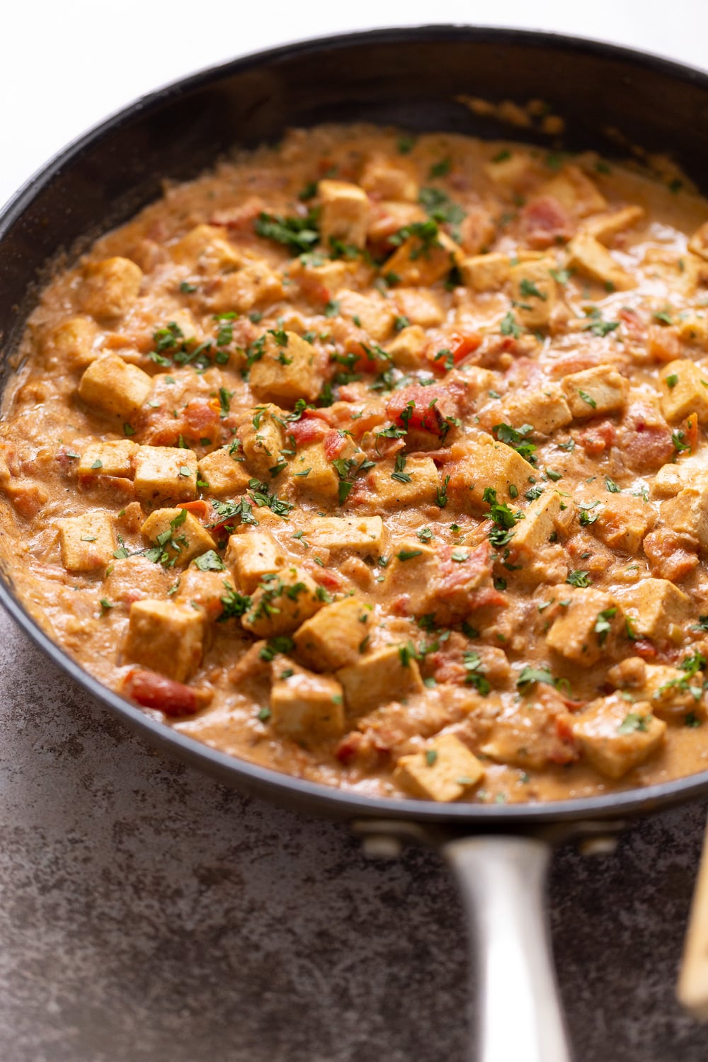 side view of a skillet with Indian Vegan Tofu Dum Kali Mirch sprinkled with fennugreek