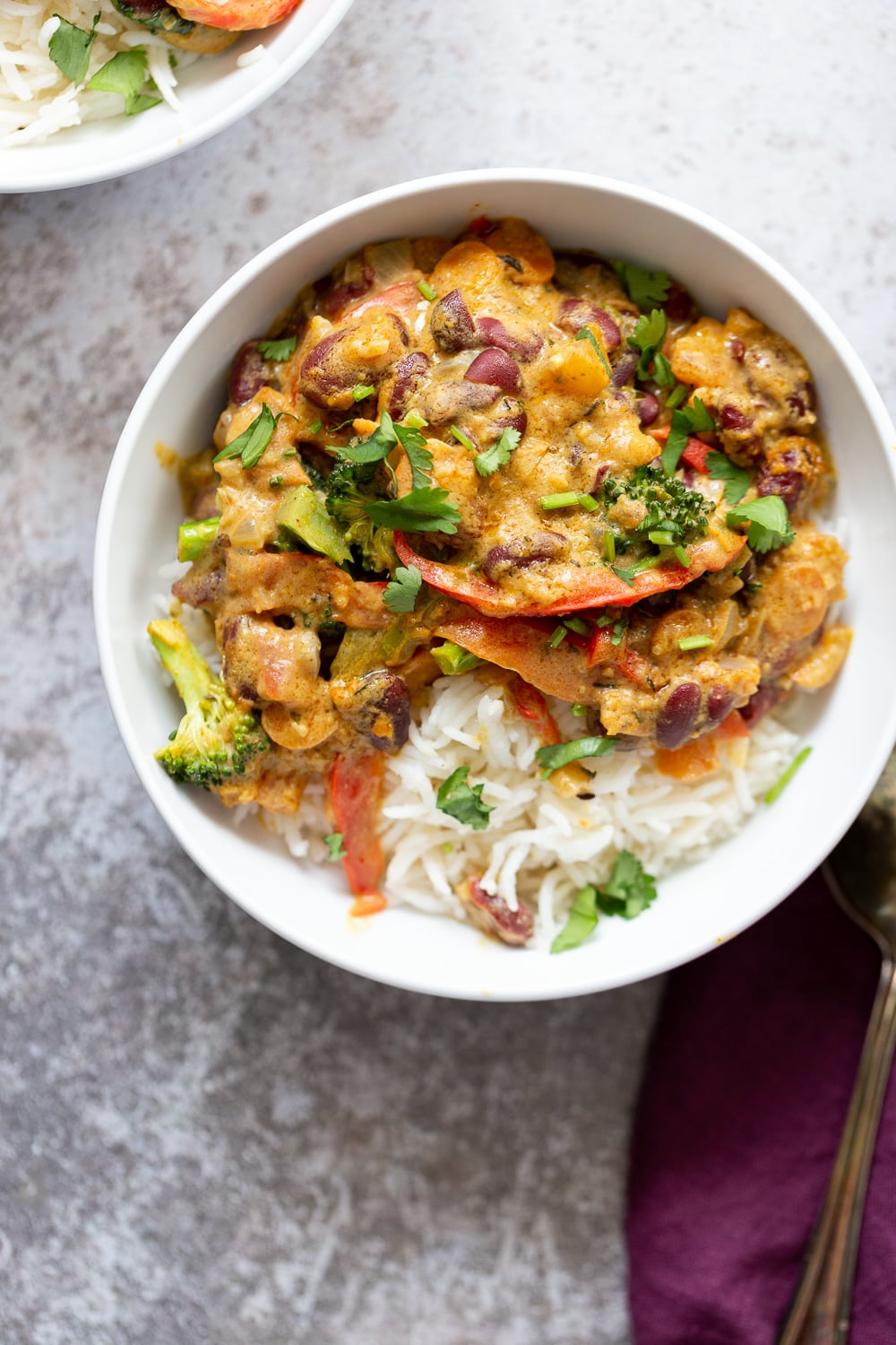 peanut stew overhead shot of a bowl of creamy vegan coconut peanut stew with veggies and kidney beans served over rice
