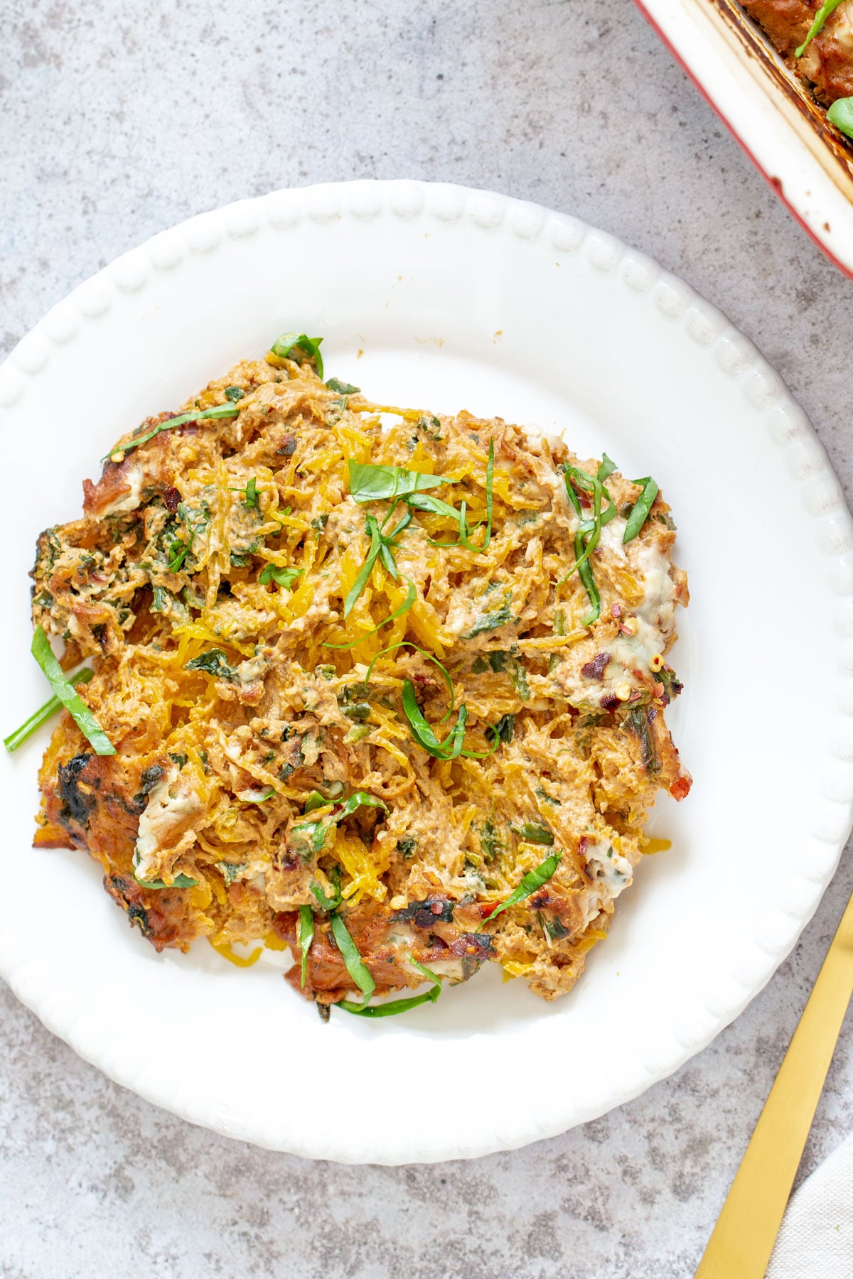 spaghetti squash bake a serving of vegan spaghetti squash pasta bake on a white plate with a golden fork