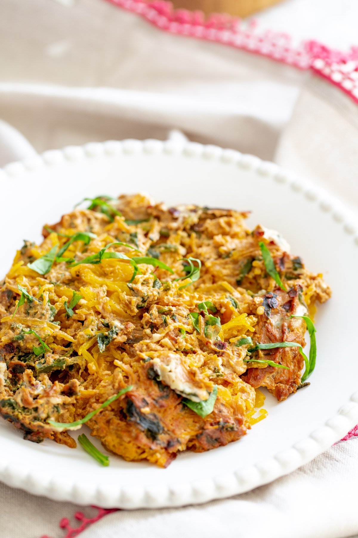 spaghetti squash bake side view of a plate with vegan spaghetti squash bake with creamy tomato sauce