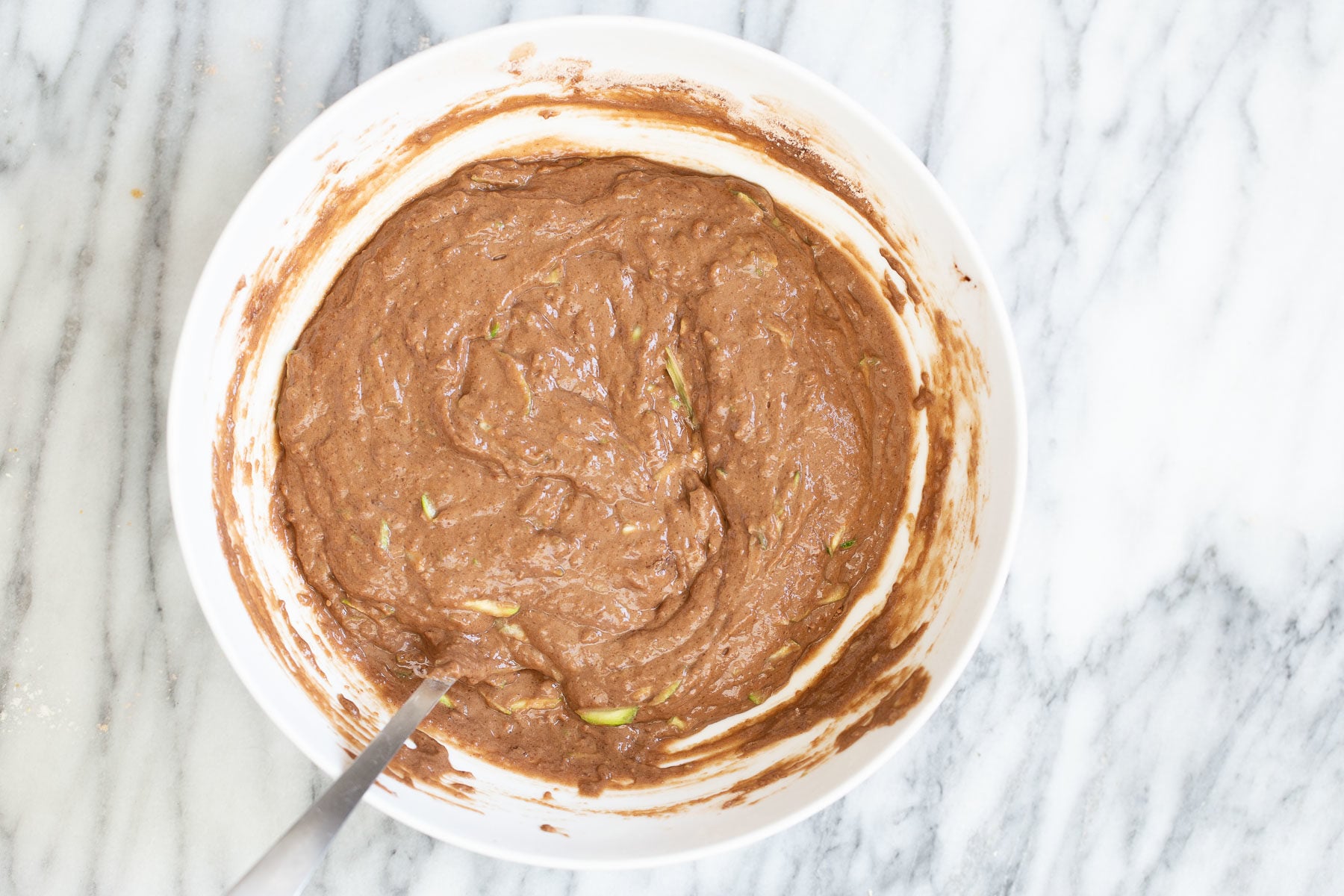 chocolate zucchini cake batter in a white bowl 