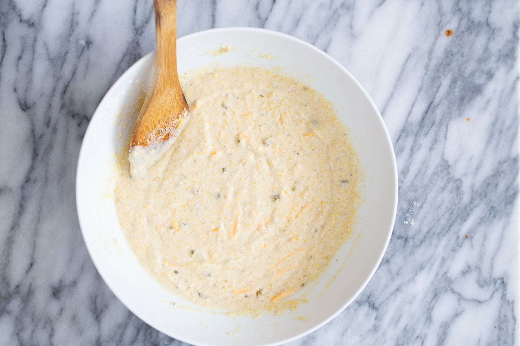 cornbread batter with pieces of jalapeno and cheddar shreds 