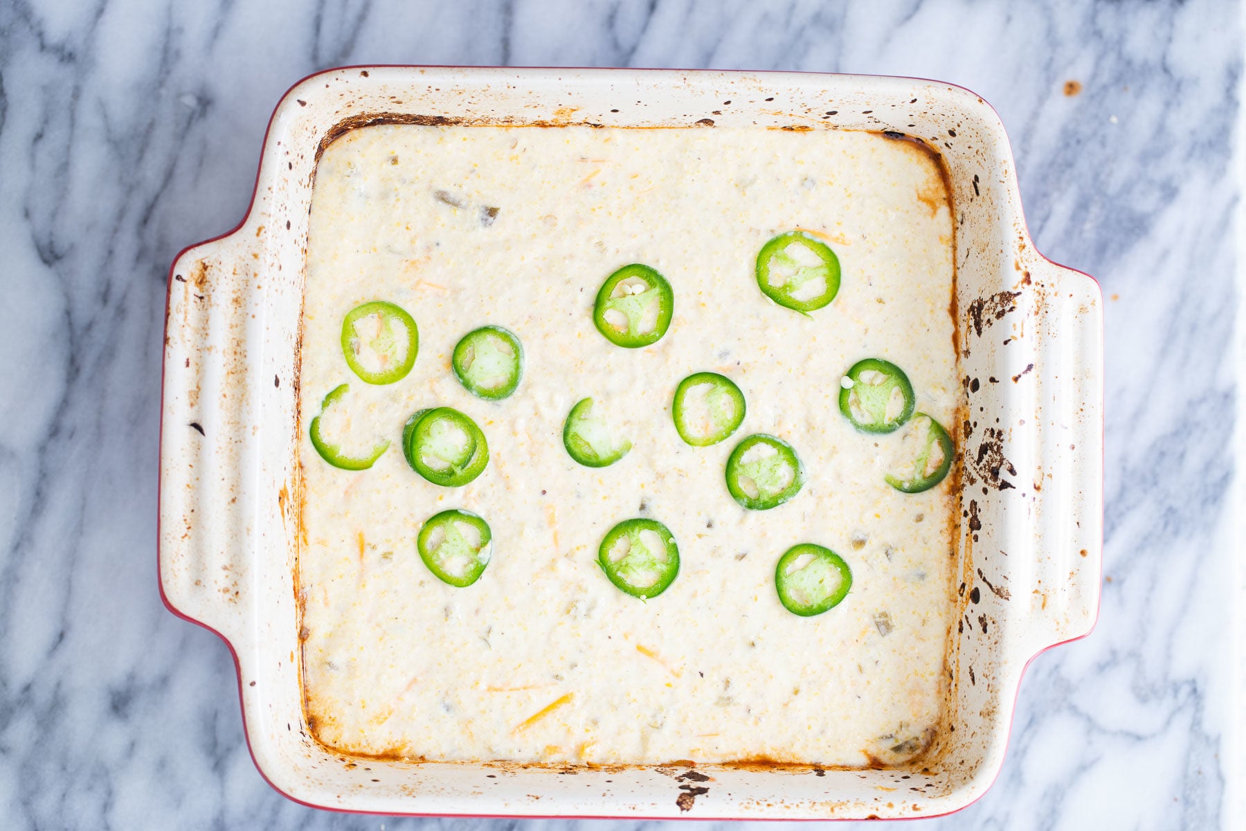 chili cornbread casserole topped with jalapeno rounds 