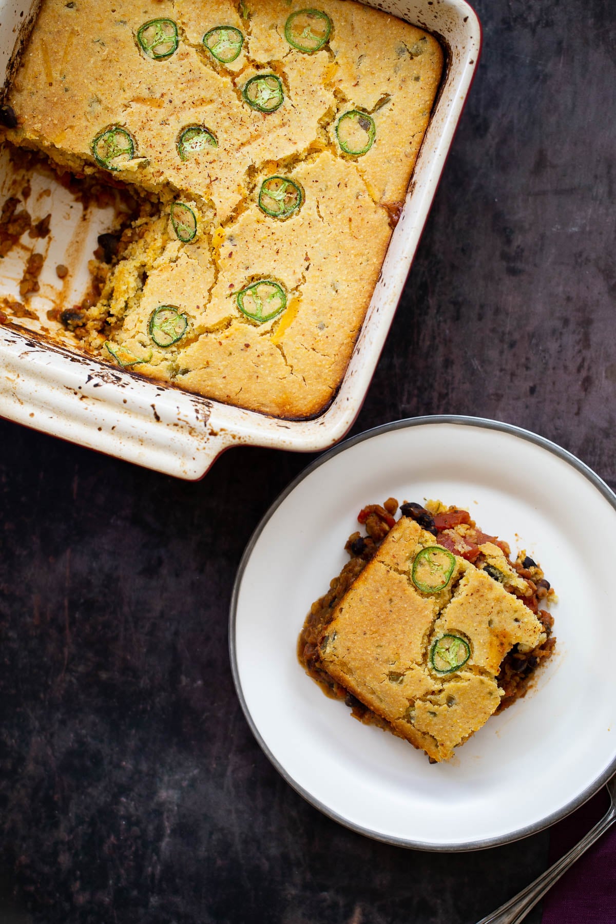 overhead shot of a chili cornbread casserole with one square cut an served 