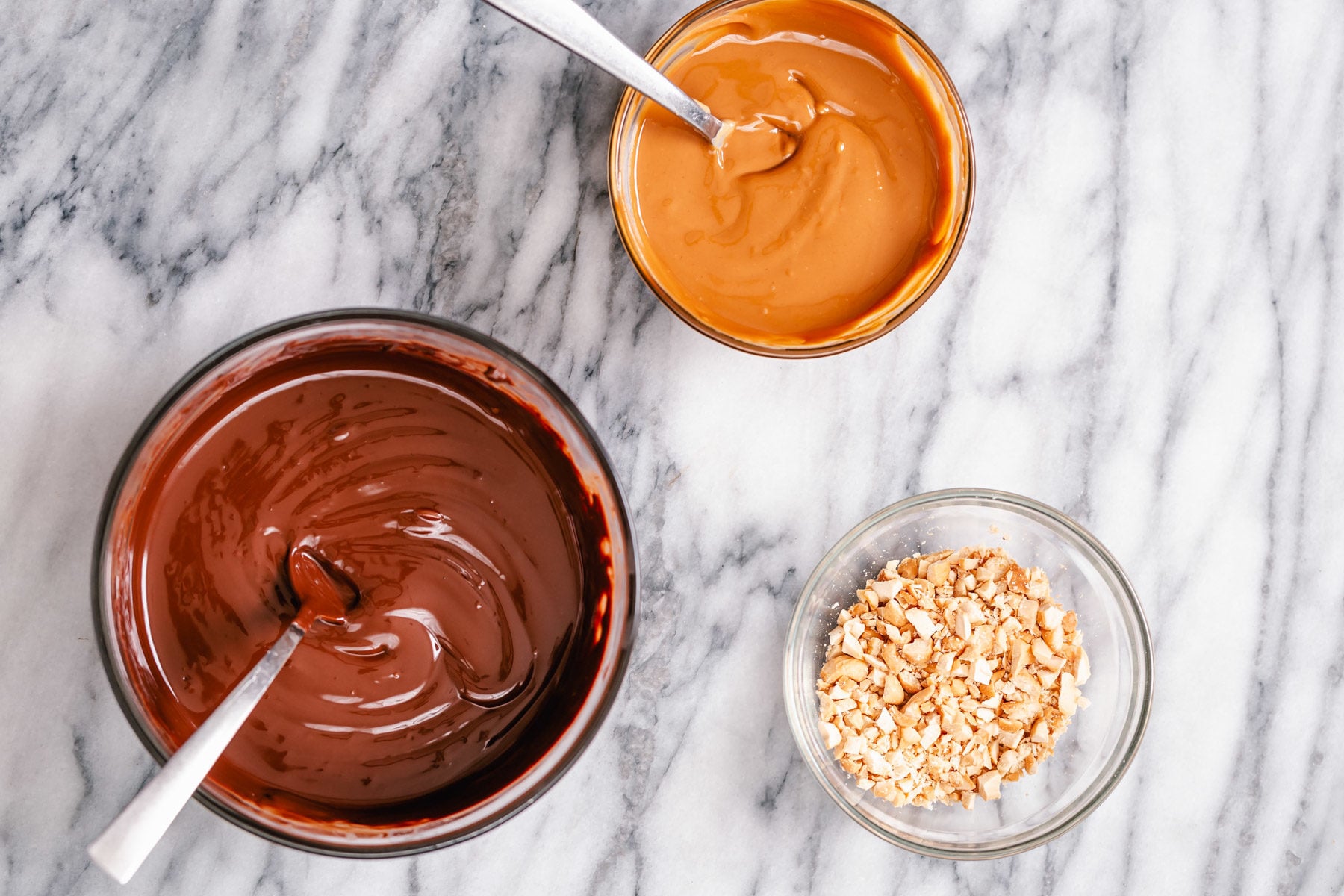 peanut butter chocolate bark melted chocolate, melted peanut butter and crushed peanuts ready for making peanut butter chocolate bark