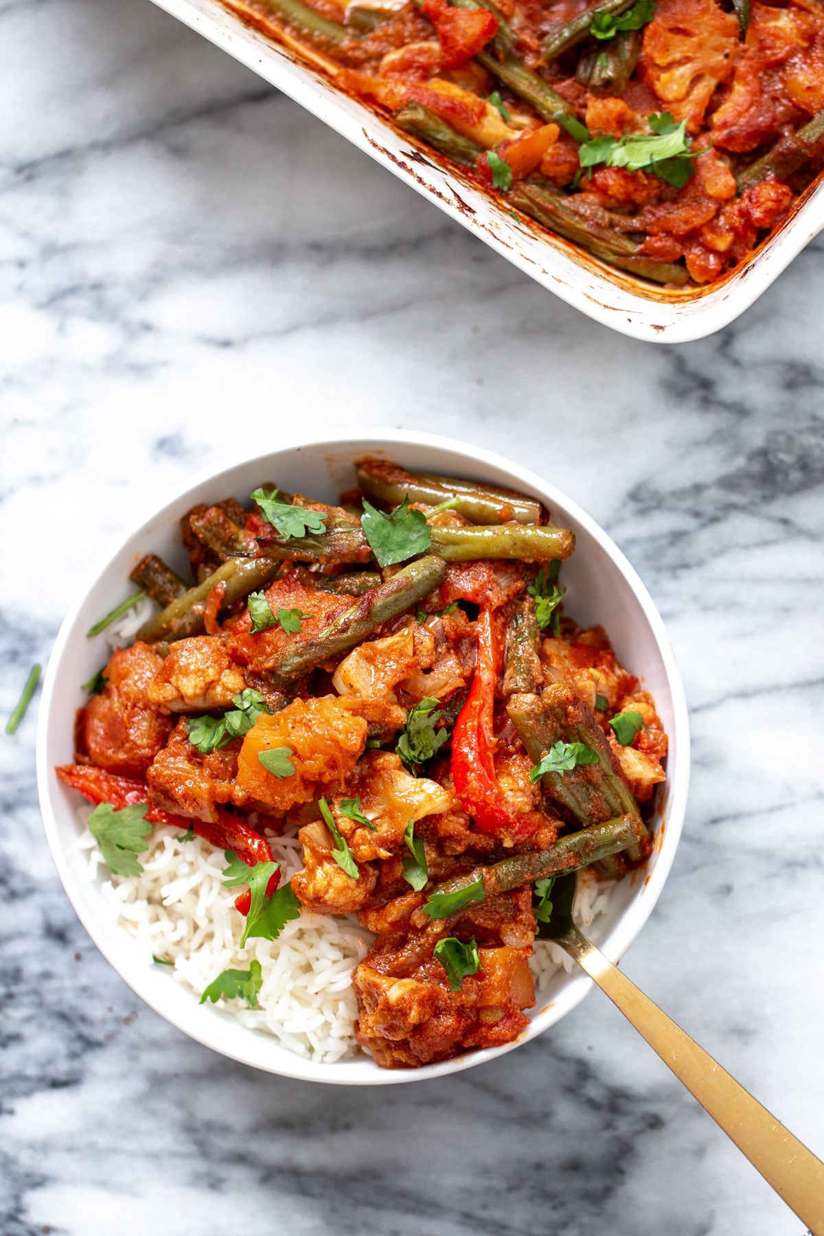 vegan vegetable casserole served in a bowl with rice and sprinkled with cilantro