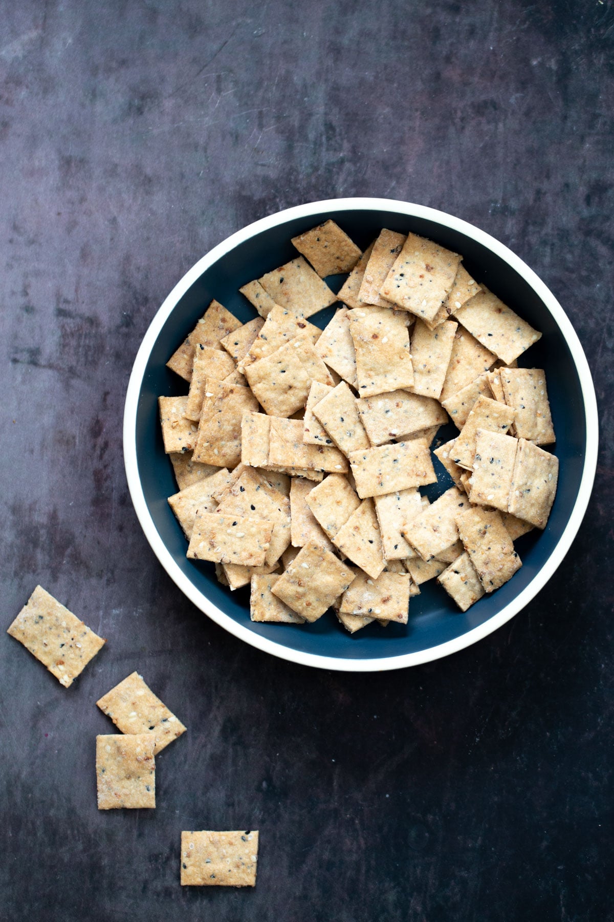 a bowl with vegan everything bagel crackers 