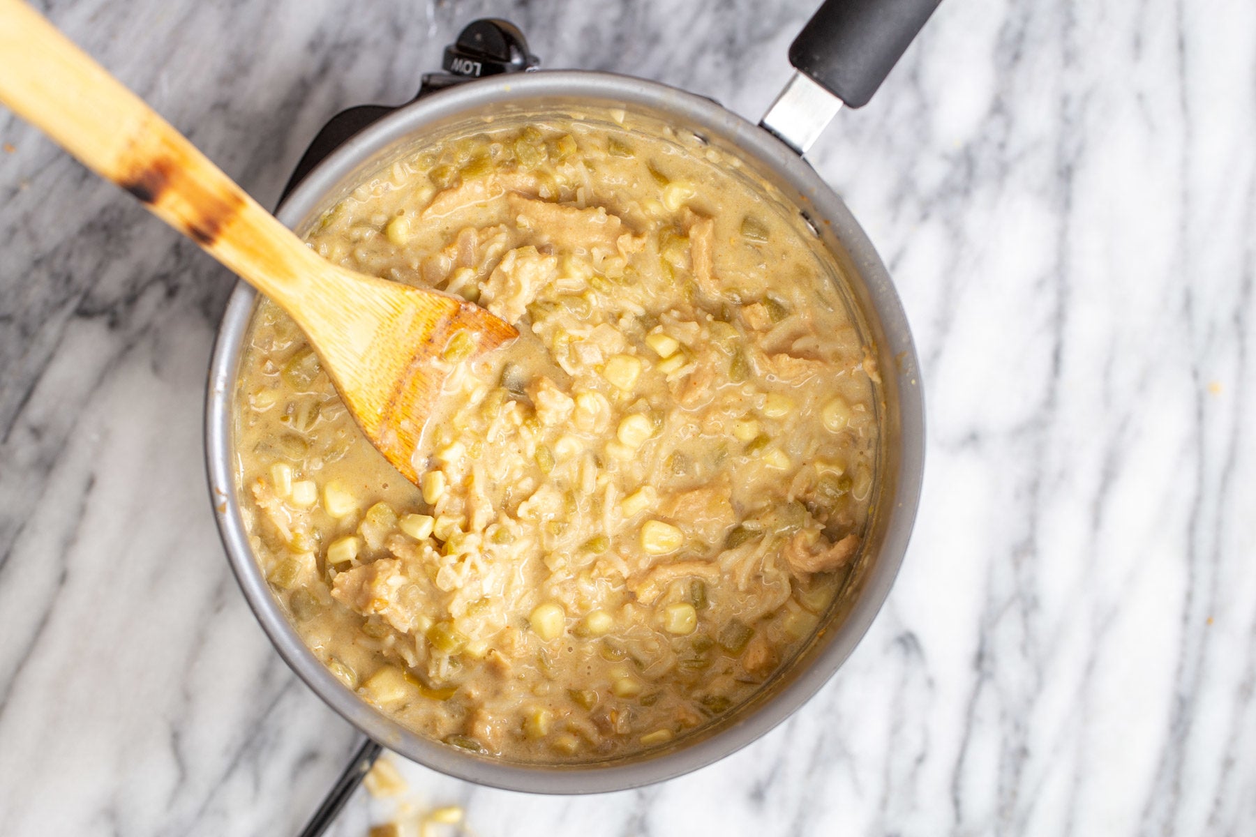vegan enchilada soup a pot of creamy vegan enchilada soup with a wooden spoon