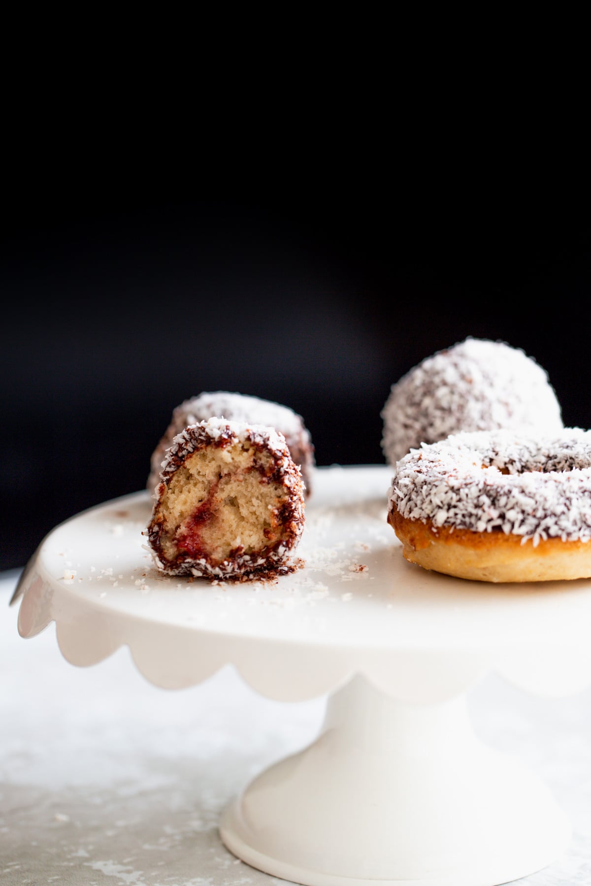 side view of a vegan lamington donut hole with one bite taken 