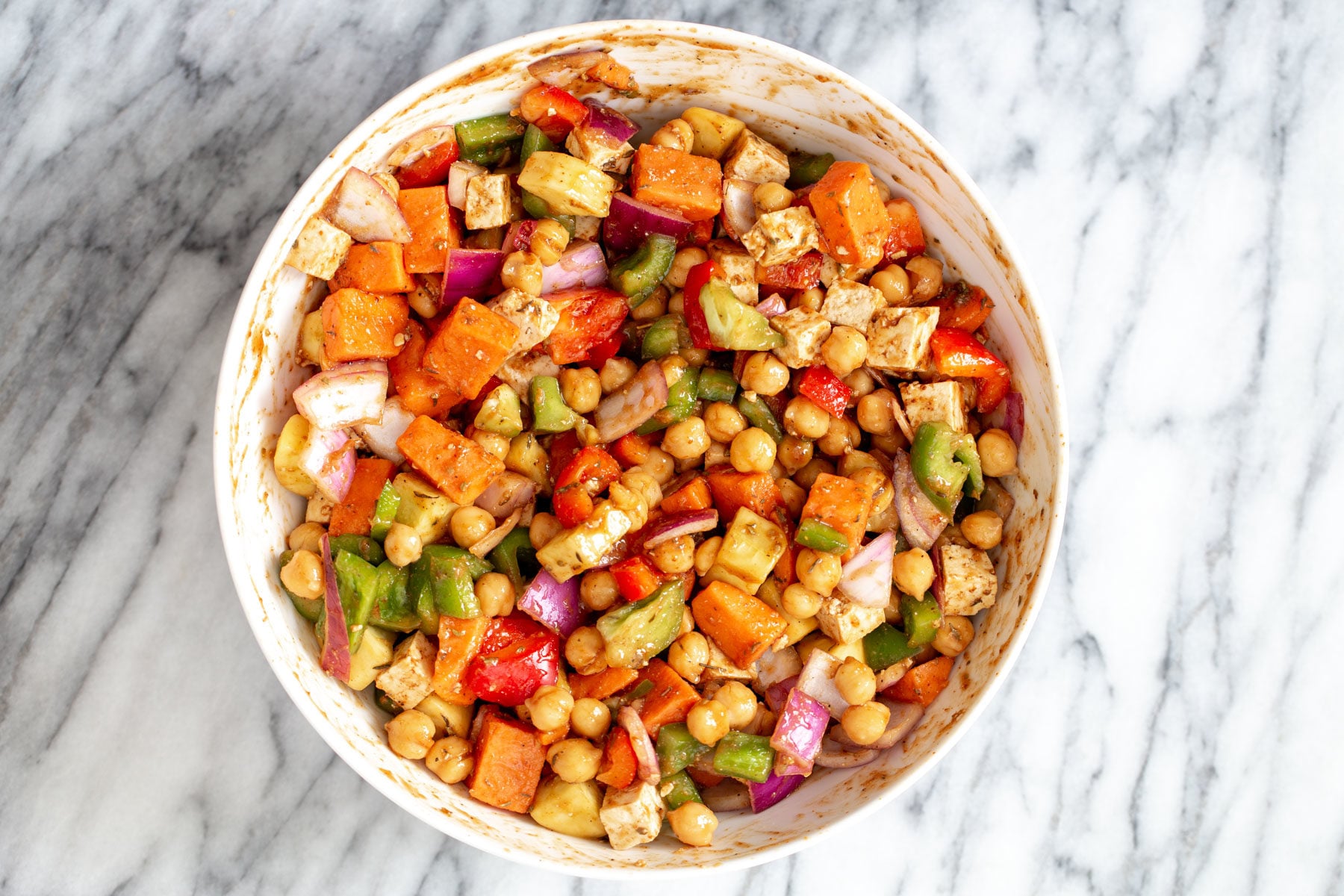 sheet pan cheeseburger vegetables being tossed with cheeseburger sauce