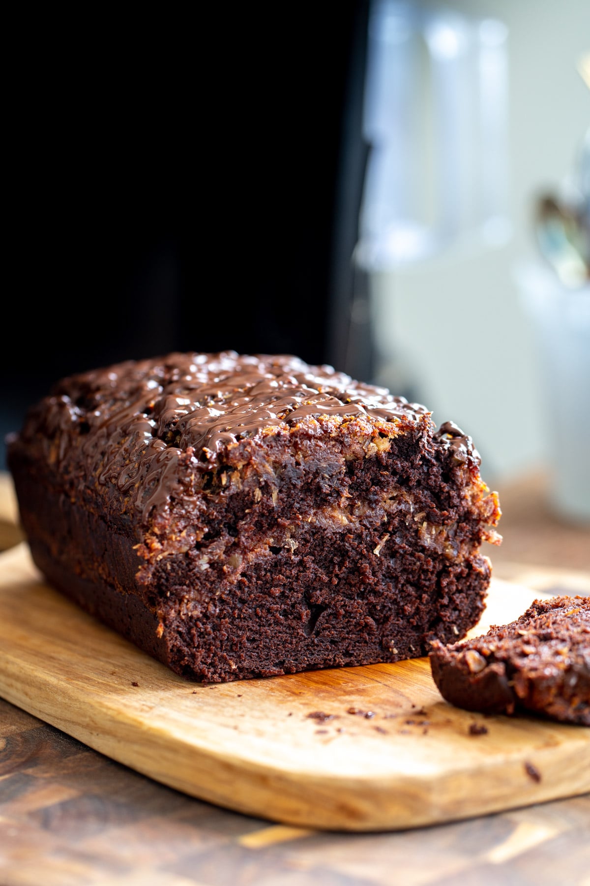 Vegan German chocolate loaf cake with one slice cut