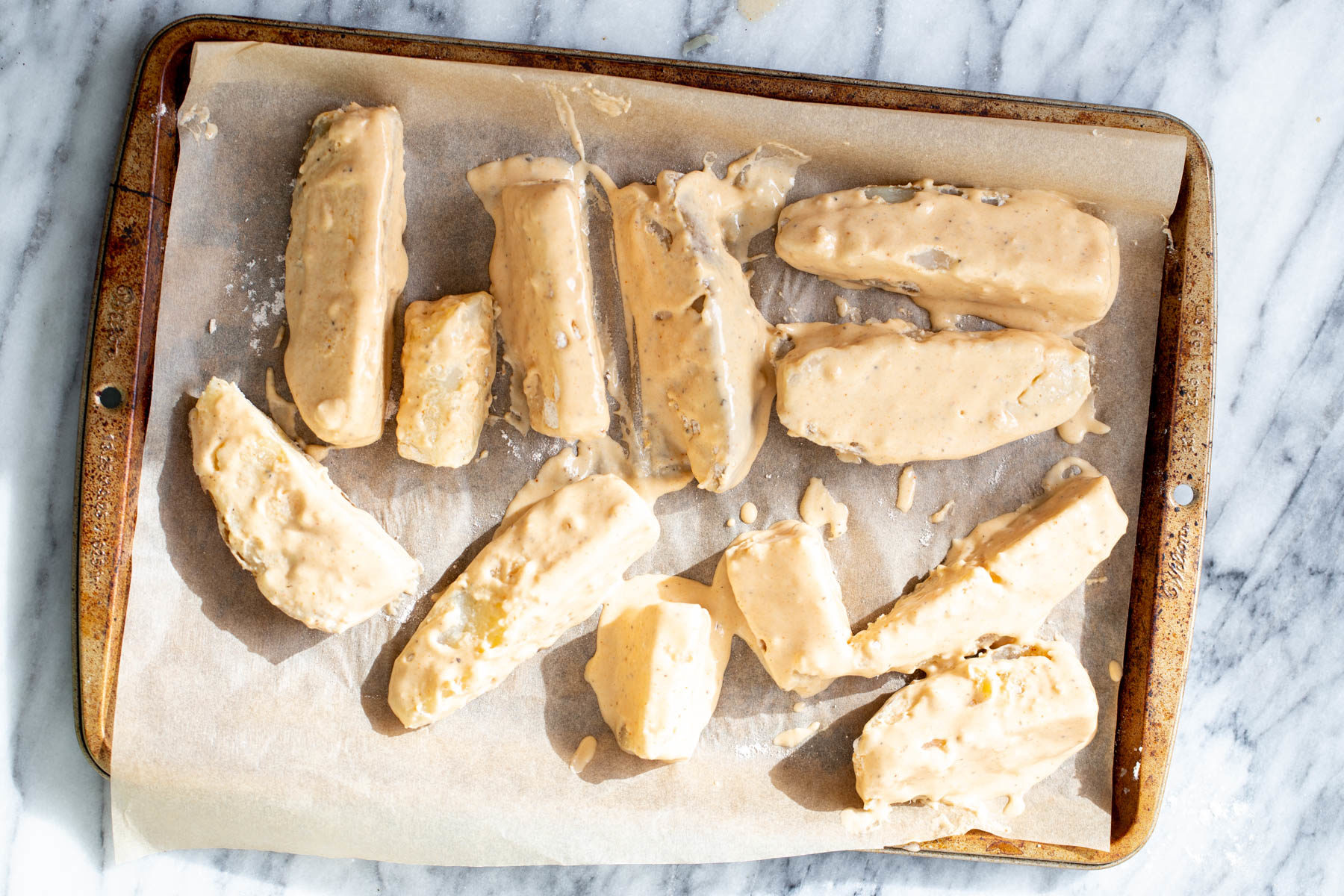 jo jo potatoes battered breaded jo jo potatoes on a sheet pan ready to be baked