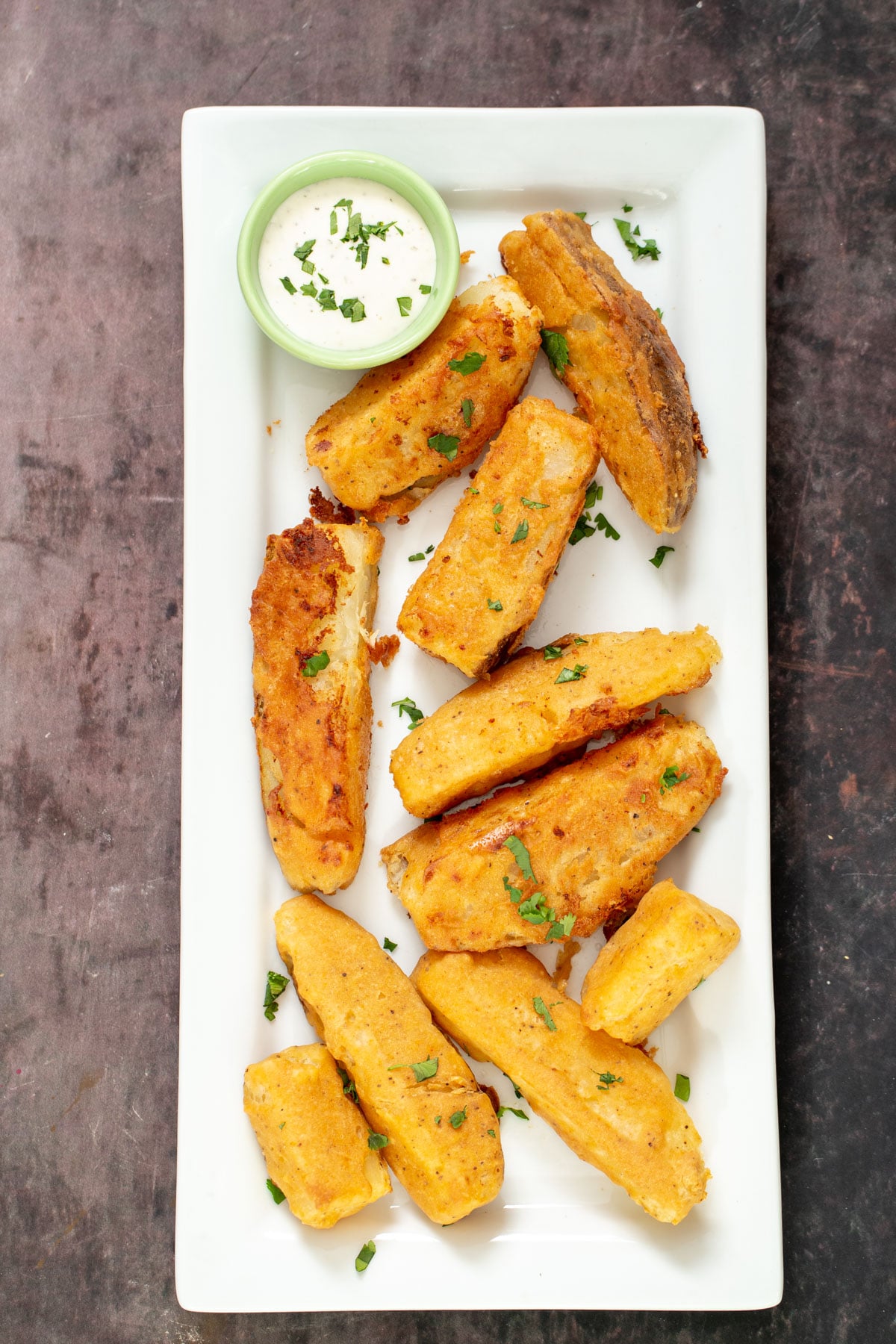 overhead shot of jo jo potatoes on a white plate with a side dish with ranch dip