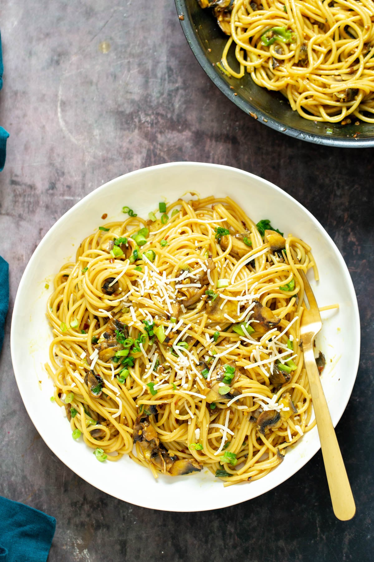 vegan garlic noodles served on a white plate with a golden fork 