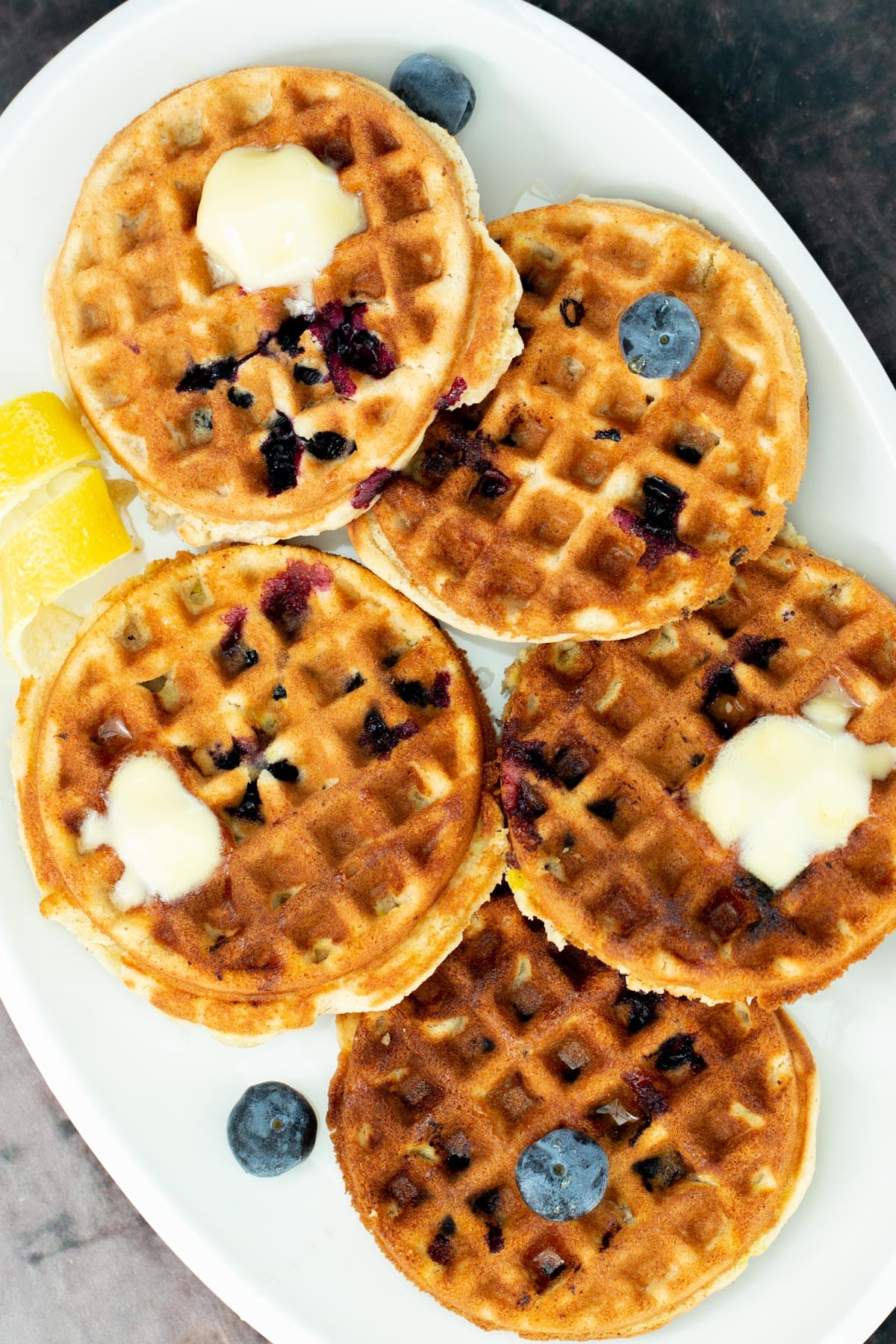 glutenfree lemon blueberry waffles a plate of vegan glutenfree lemon blueberry waffles topped with dollops of butter and fresh blueberries