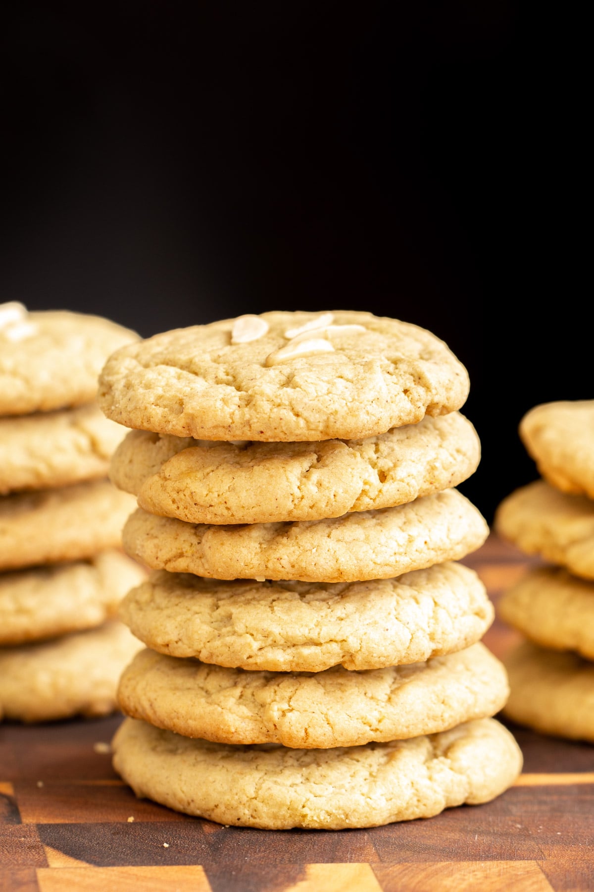 side view of a stack of vegan almond pistachio cookies on a wooden board 