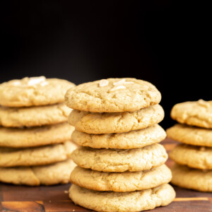 vegan pistachio cookies stacked on a wooden board