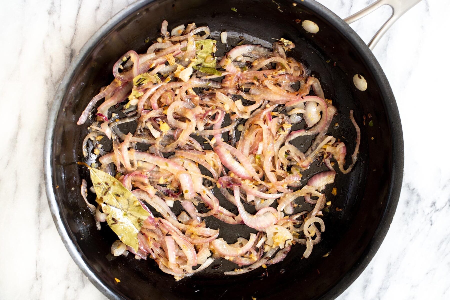 onion and spiced being fried in a pan