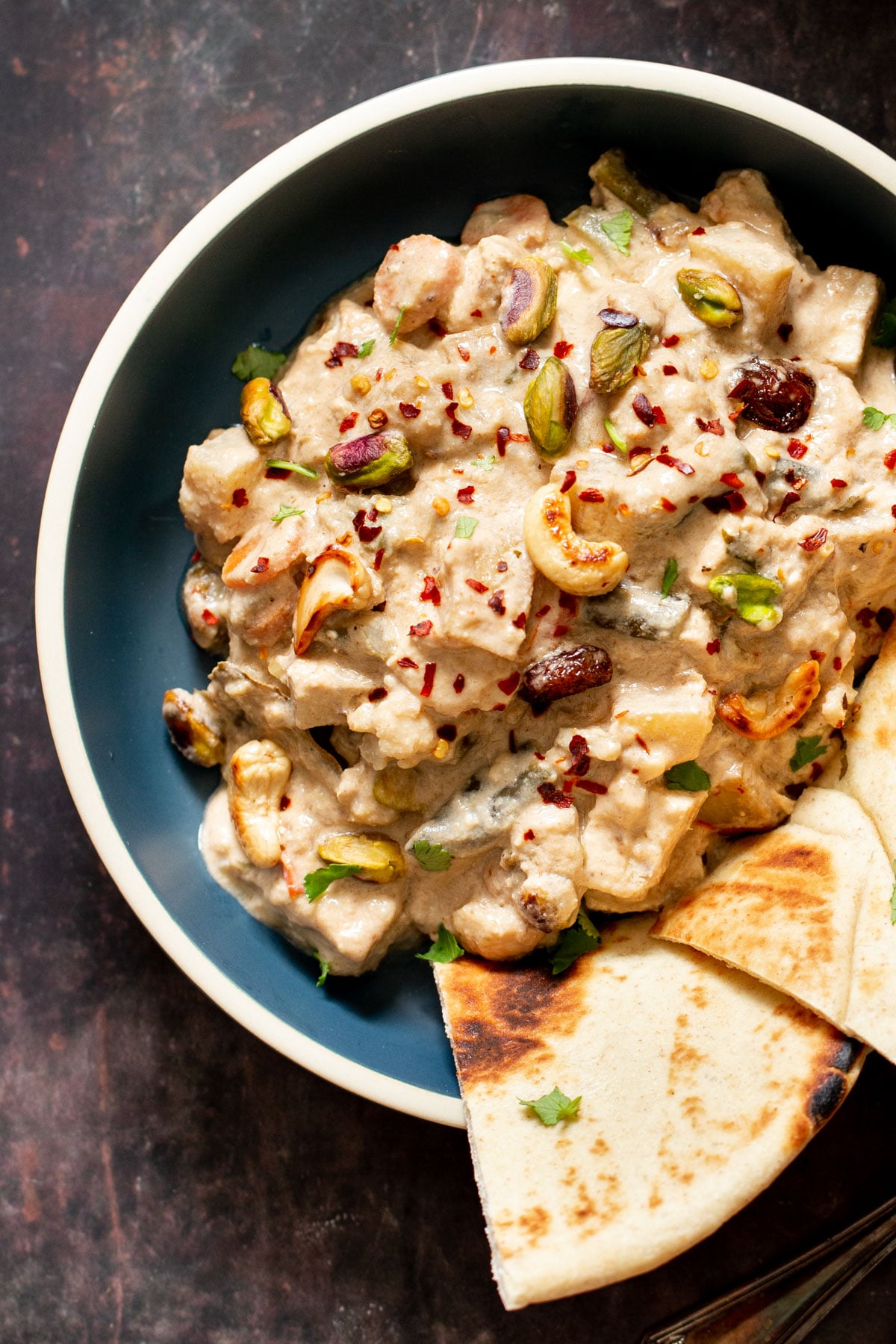 a bowl with creamy Indian Navratan Korma sprinkled with chili flakes