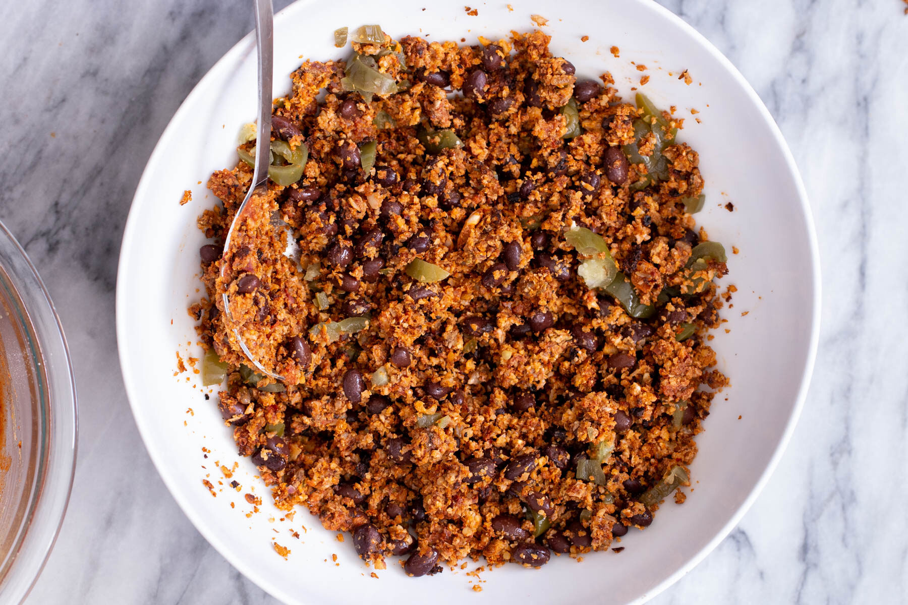 beans and green chilies being mixed into cauliflower taco meat