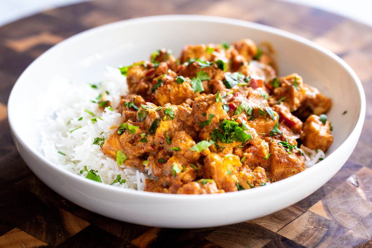 a plate with vegan tofu rogan josh served with rice