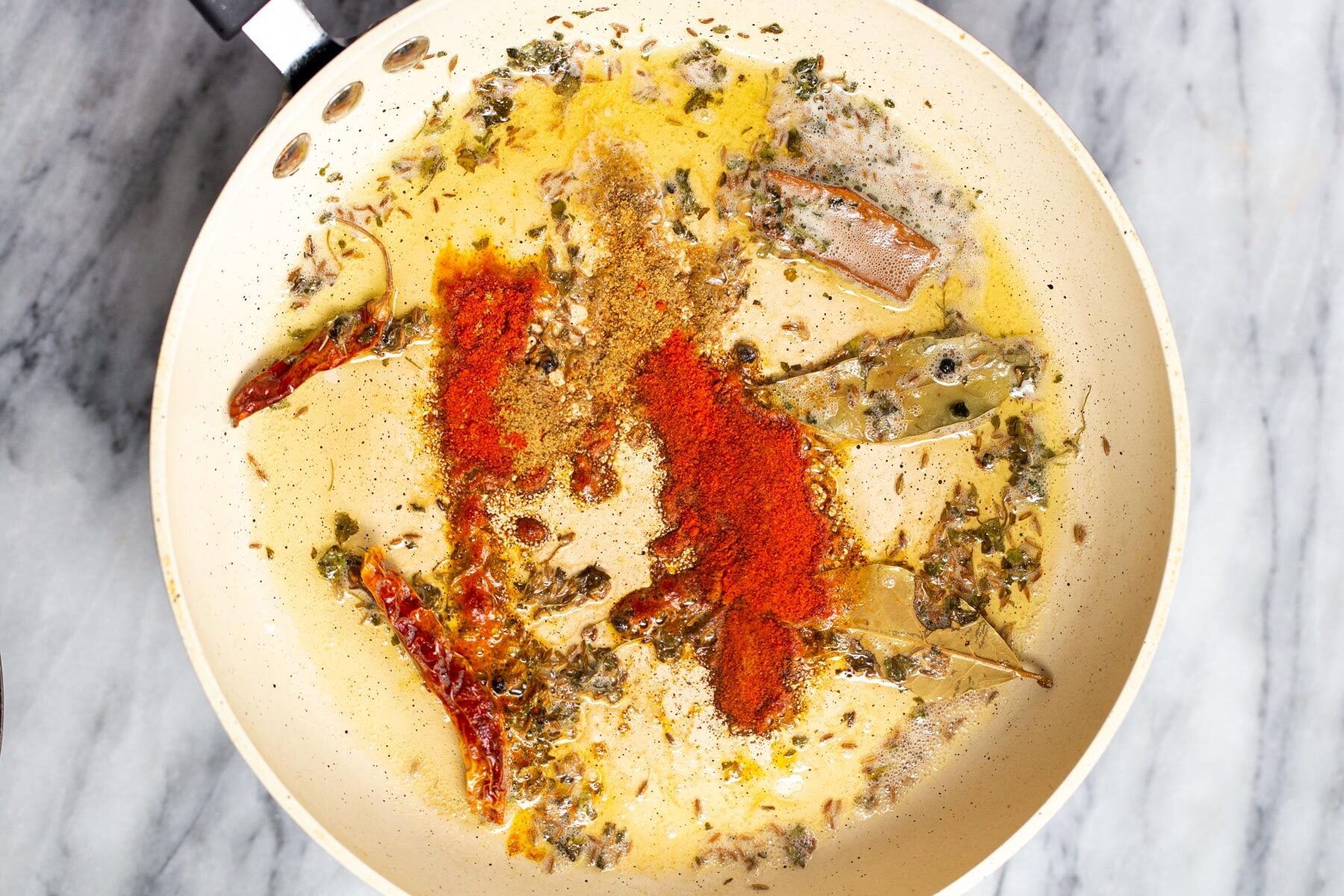 ground spices being added to tempering for dal recipe