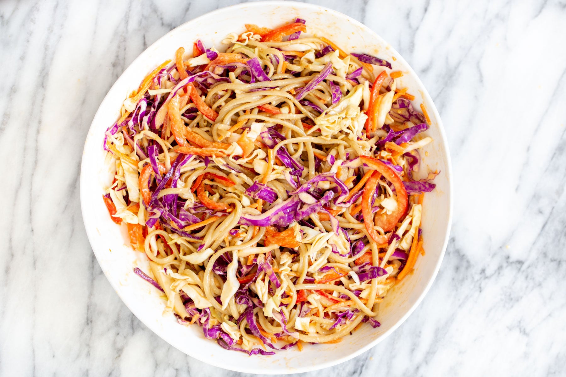a white bowl with peanut sesame noodle salad