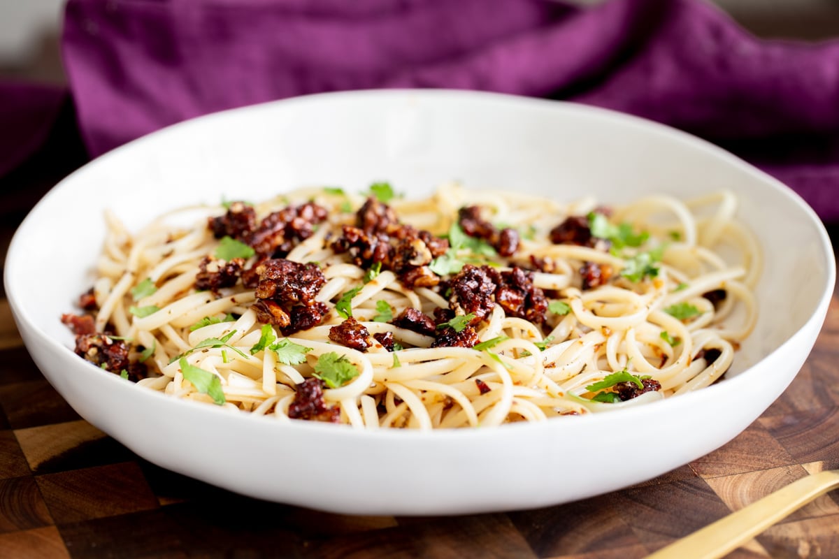 vegan pasta with chili garlic oil topped with candied pecans