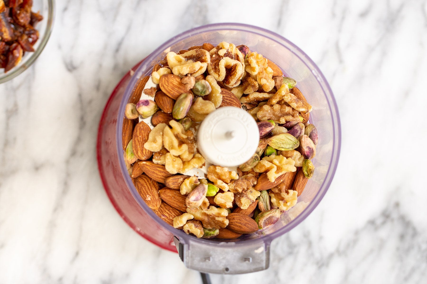 mixed nuts in a food processor container 