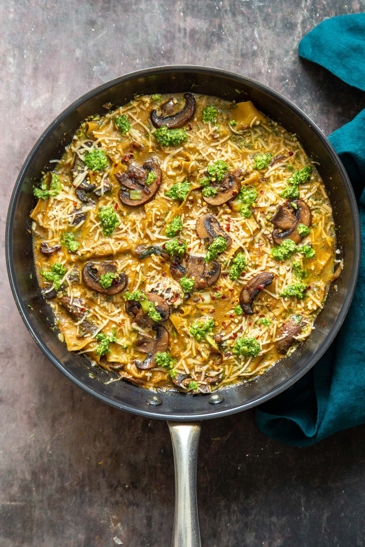 overhead shot of a black skillet with vegan one pan mushroom and pesto lasagna