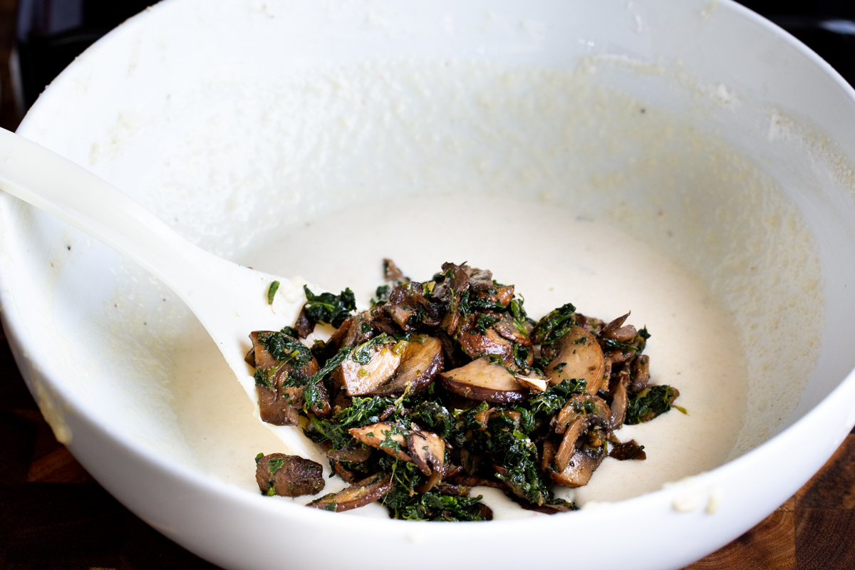 spinach mushroom mix being added to vegan naan batter