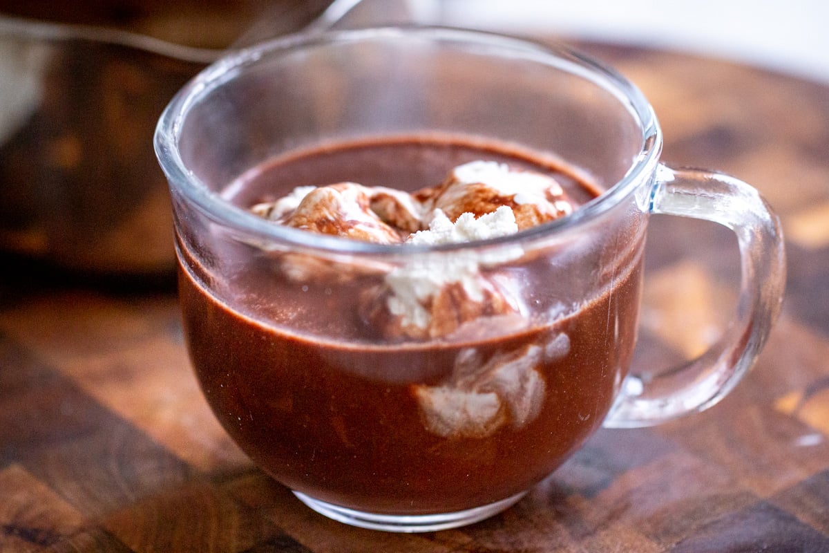 a glass with vegan hot chocolate topped with coconut cream