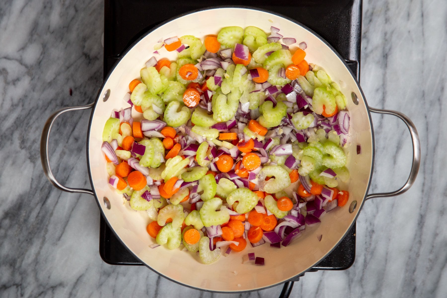 carrots, onions and celery in a sauteeing pan